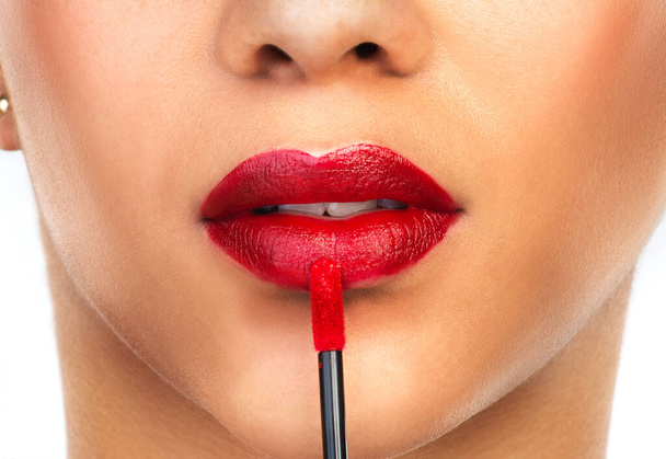 Legen Sie sich einen roten Lippenstift auf und leben Sie ein wenig. Schnappschuss einer unkenntlichen Frau, die roten Lippenstift auf ihre Lippen aufträgt. - Foto, Bild