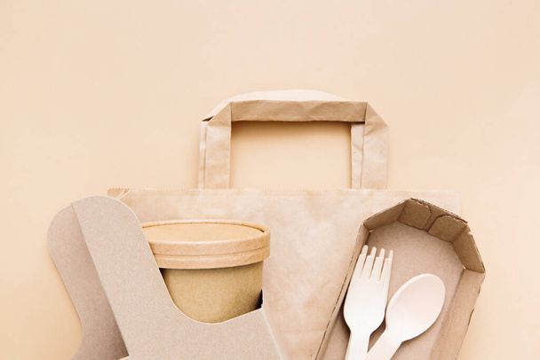Zero waste, environmentally friendly, disposable, cardboard, paper utensils on a beige background. View from the top. Eco craft paper tableware. - Fotó, kép