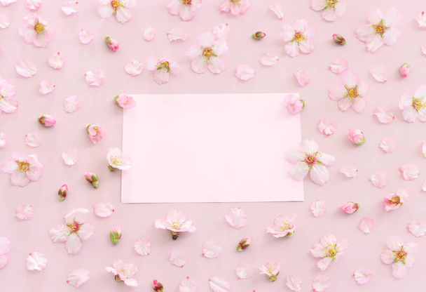 obrázek jarní bílé třešňové květy strom a prázdný papír přes růžové pastelové pozadí - Fotografie, Obrázek