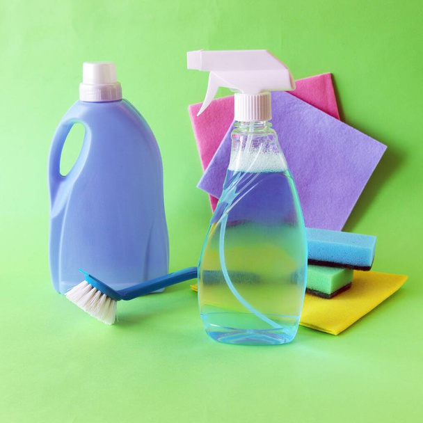 Plastik şişelerdeki sıvı deterjanlar, masadaki temizlik ürünleri, yeşil arka plan, temizlik, düzen, temizlik, ev teslimatı. - Fotoğraf, Görsel