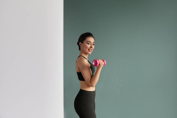 Sport fitness, and healthy lifestyle concept - smiling young woman with dumbbells exercising at home - Foto, Imagen