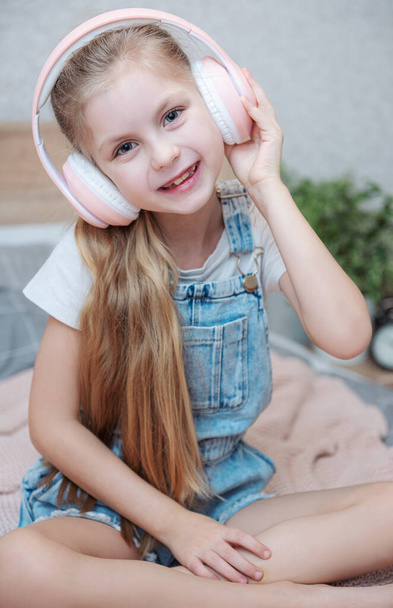 Adorable little girl in headphones enjoy with a music. - Foto, afbeelding