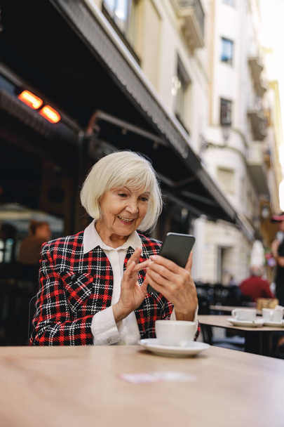 Photo of charming woman using smartphone outdoors - Photo, Image