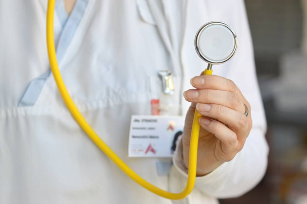 Doctora sosteniendo un estetoscopio. Concepto de salud y medicina. Fondo hospitalario. - Foto, Imagen