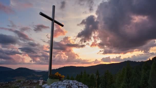 Krzyż chrześcijański na szczycie góry o zachodzie słońca, scena upływu czasu religijnego, 4K - Materiał filmowy, wideo