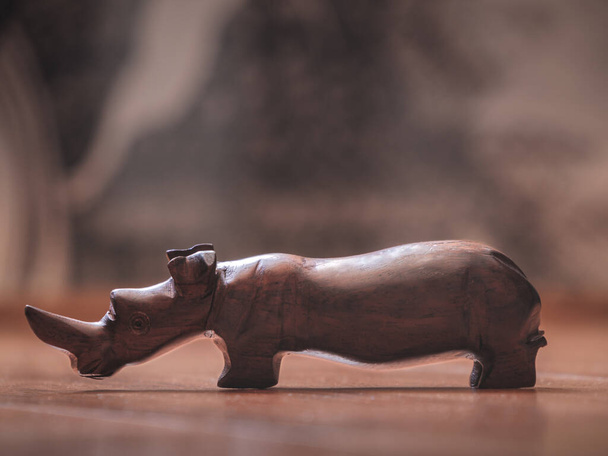 Handmade wooden rhino souvenir in ambient light - Photo, Image