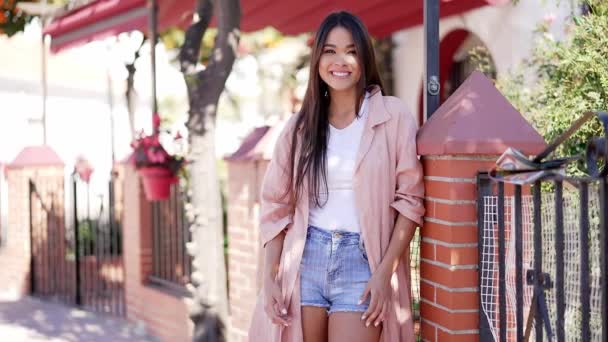 Glimlachende stijlvolle brunette leunend op hek - Video