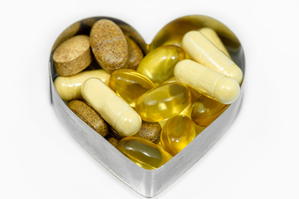 Multi Vitamin pills in heart isolated - Photo, Image