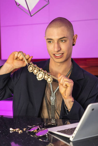Influenciador gay queer na moda mostrando aos seus seguidores toda a sua coleção de jóias, e falando sobre as tendências da moda em seu novo vídeo. Foto vertical. - Foto, Imagem