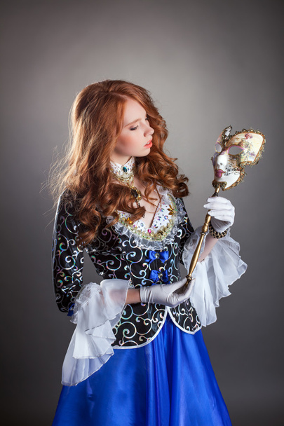 Lovely red-haired girl posing with masquerade mask - Fotografie, Obrázek