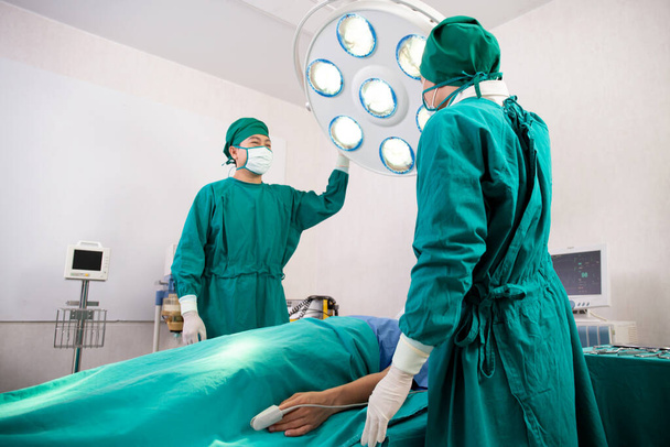 Przygotowanie lekarza i chirurga z ratowaniem i ratowaniem pacjenta na sali operacyjnej w szpitalu, chirurgii i nagłych wypadkach, medycynie i technice, chirurgii i zdrowiu, specjalisty i asystenta. - Zdjęcie, obraz