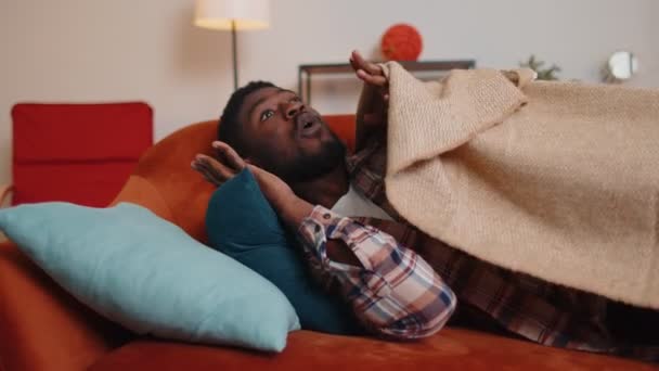 Děsivý strach africký americký mladý muž se probouzí ze stresu noční můra v ložnici doma pohovka - Záběry, video