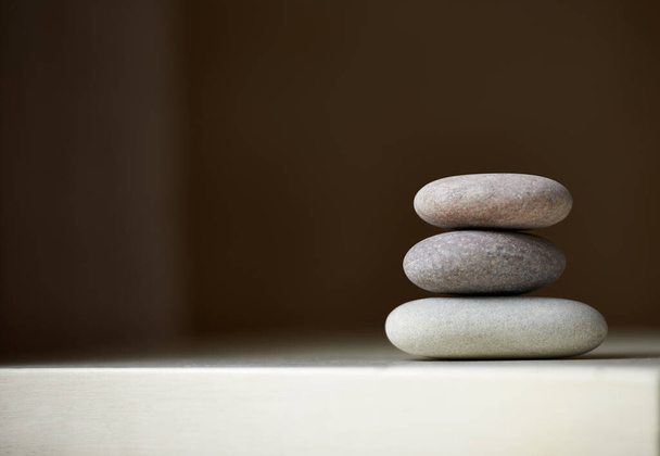 Encuentra tu equilibrio. Tres piedras equilibradas una encima de la otra en luz natural. - Foto, imagen