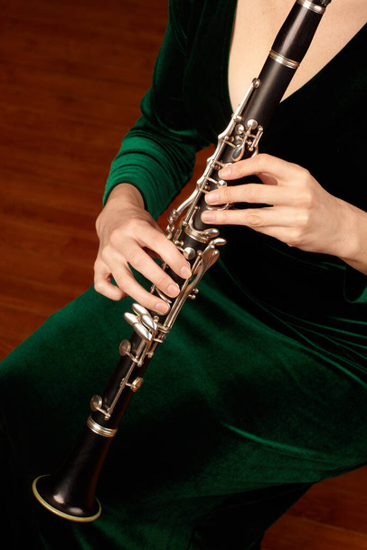 Holzbläserwunder. Ein abgeschnittenes Bild einer Klarinette spielenden Frau. - Foto, Bild