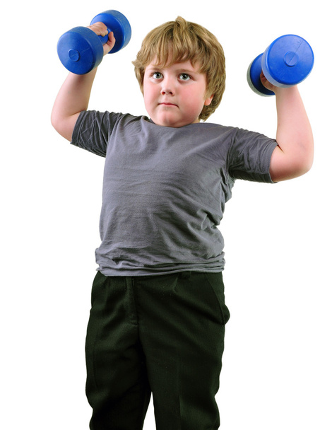 Isolated portrait of elementary age boy with dumbbells exercising - Foto, imagen