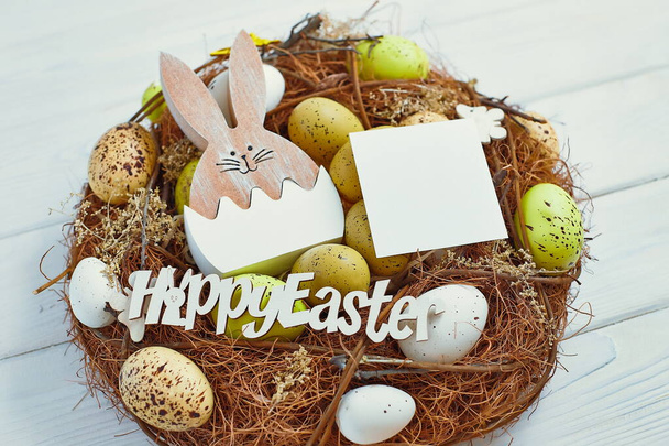 Easter eggs in the basket of wooden boards. yellow chicks on a  wooden background. The minimal concept. An Easter card with a copy of the place for the text. - 写真・画像