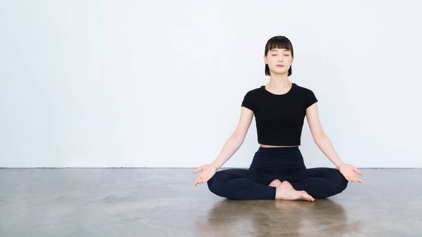 Asian young woman doing mantra meditation in yoga pose - Foto, afbeelding