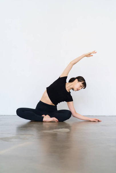Junge Frau bei Yoga und flexiblen Übungen im Haus - Foto, Bild