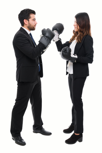 Ambiciosos representantes de ventas en trajes negros con guantes de boxeo y uno frente al otro para una pelea - Foto, Imagen