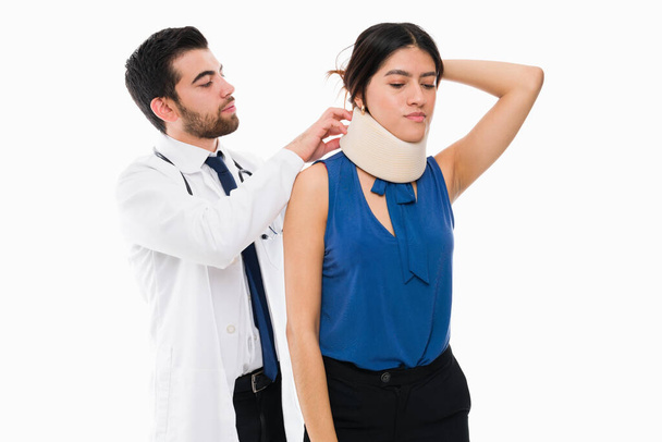 Az ortopéd orvos nyakmerevítőt tett egy fiatal nőre egy autóbaleset után. Nyaki sérülést szenvedett beteg az orvosnál  - Fotó, kép
