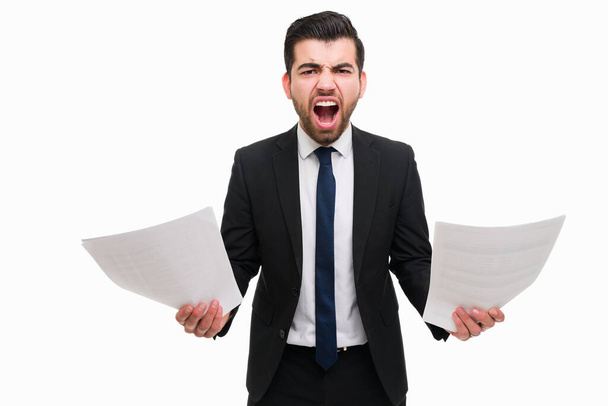 Angry lawyer looking at legal papers and feeling furious about work mistakes. Upset professional boss screaming and looking at the camera - 写真・画像