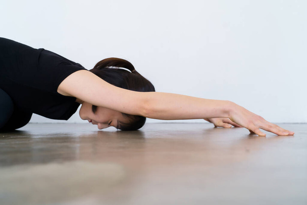 jeune femme faisant du yoga (pose d'enfant)  - Photo, image