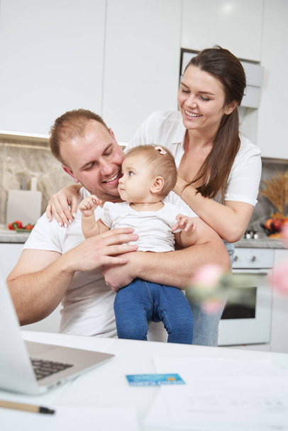 Parents playing with their baby at table in kitchen - Photo, Image