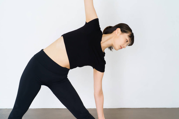 Mujer joven haciendo yoga (pose triangular) - Foto, Imagen