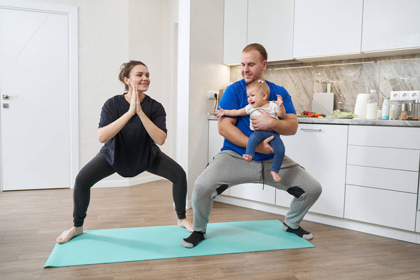 Husband and wife doing squats with their child - Foto, immagini