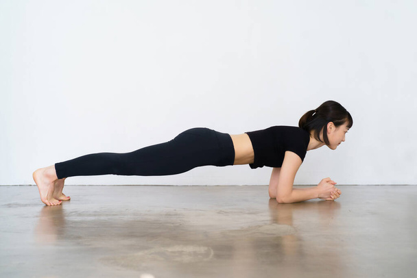 Jonge vrouw doet yoga (board pose)  - Foto, afbeelding