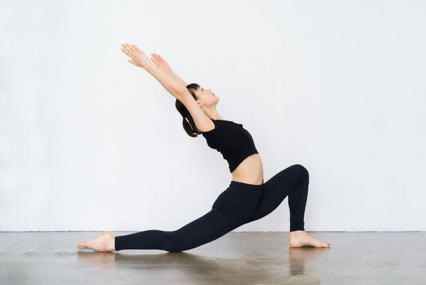 Mujer joven haciendo yoga (pose creciente)  - Foto, Imagen