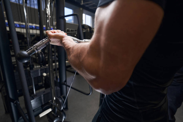 Homme musclé fort montrant ses biceps pendant l'entraînement - Photo, image