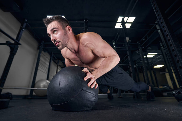 Skupione zdjęcie sportowca wykonującego ćwiczenia push-upy - Zdjęcie, obraz