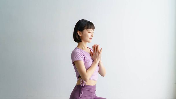 Una mujer haciendo yoga posa con sus palmas juntas - Foto, Imagen