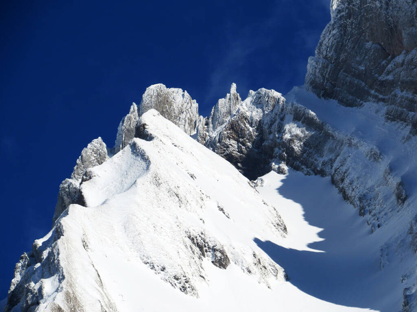 雪に覆われた高山の牧草地と冬の服装でアルプシュタイン塊の岩のピーク(付録アルプスの塊), Unterwasser -サンガレンのカントン,スイス(スイス)) - 写真・画像