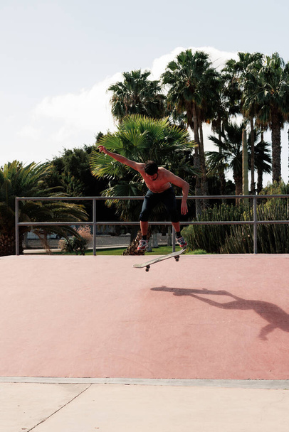 Skateboarder doing a trick in a skate park - Foto, Bild