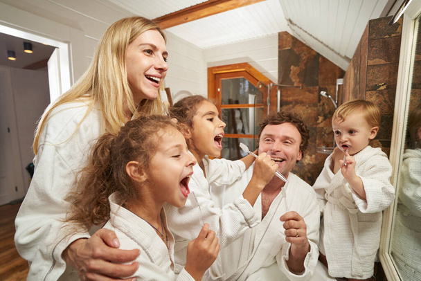 Портрет усміхненого батька, мами і дітей вдома
 - Фото, зображення