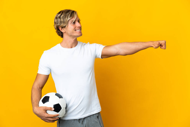 Jugador de fútbol inglés sobre fondo amarillo aislado dando un gesto pulgar hacia arriba - Foto, imagen