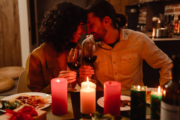White couple hugging while having romantic dinner at home indoors - Fotó, kép