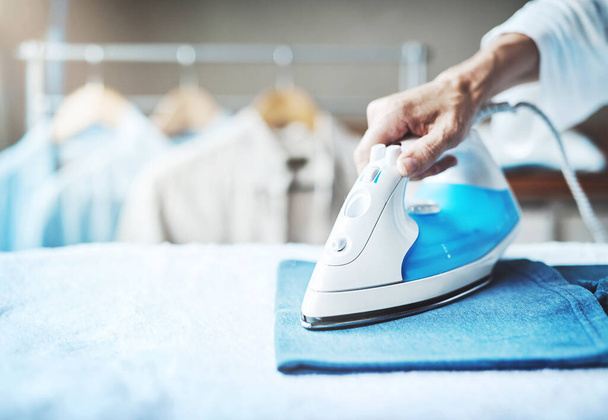 Smoothing out all the creases. Closeup shot of an unidentifiable woman ironing clothes at home. - Photo, Image
