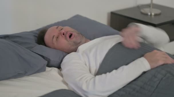 Мужчина среднего возраста кашляет во время сна в постели - Кадры, видео
