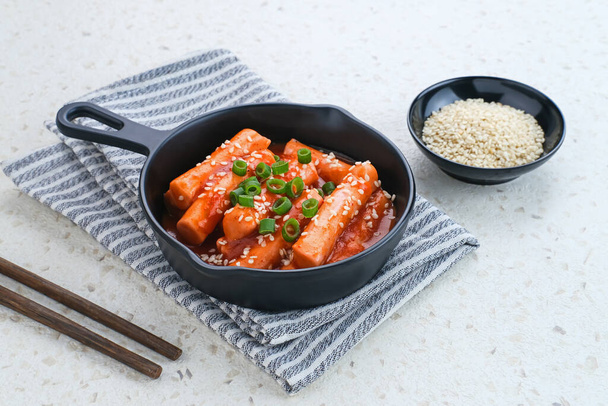 Tteokbokki nebo Topokki, zamíchejte smaženou rýžovou tyčinku, oblíbené korejské pouliční jídlo s pikantní gochujang omáčkou a sezamem.  - Fotografie, Obrázek
