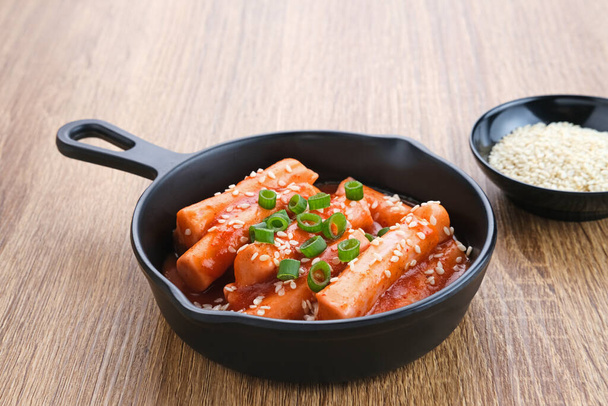 Tteokbokki vagy Topokki, keverjük össze a sült rizstortát, népszerű koreai street food fűszeres gochujang szósszal és szezámmaggal.  - Fotó, kép
