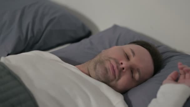 Человек средних лет чувствует себя некомфортно во время сна в постели - Кадры, видео