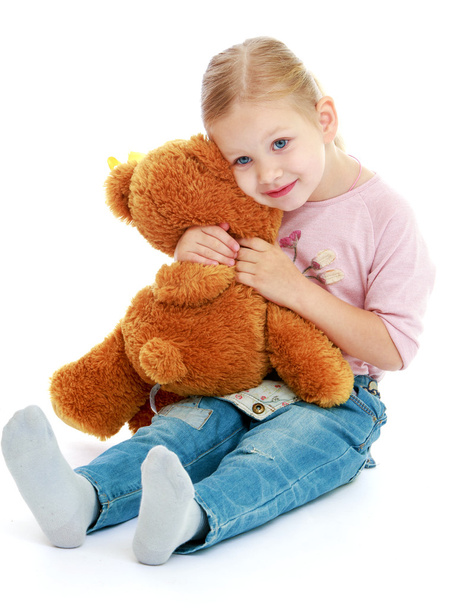 Little girl hugging a teddy bear. - Фото, изображение