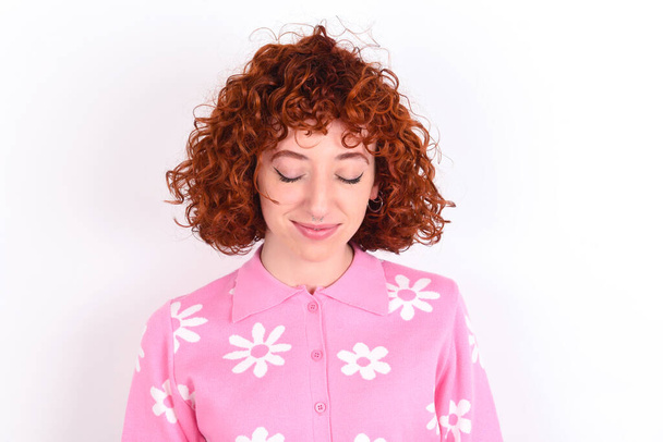 young redhead girl wearing pink floral t-shirt over white background nice-looking sweet charming cute attractive lovely winsome sweet peaceful closed eyes - Photo, Image