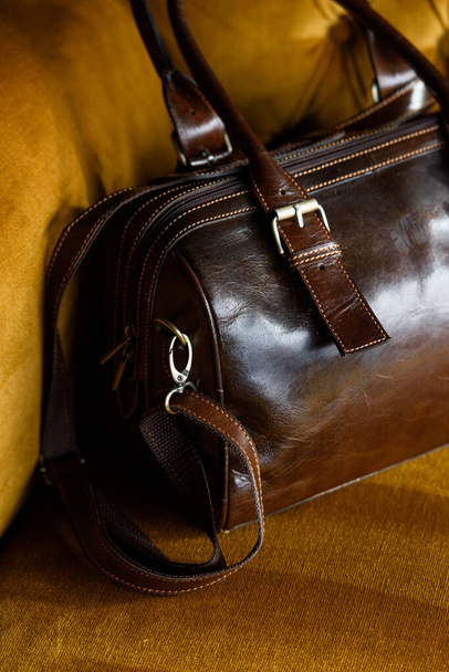 foto de cerca del bolso de cuero marrón en un sofá vintage - Foto, Imagen