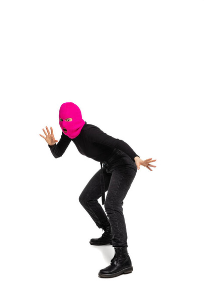 Portrait of young anonymous person wearing black outfit and balaclava isolated on white background. Concept of art, fashion, anti-terrorizm - Fotó, kép