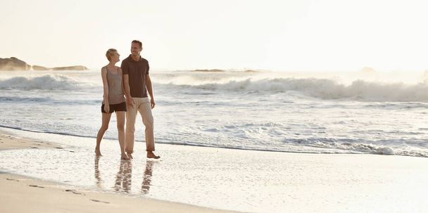 A fazer um passeio ao pôr-do-sol. Um casal amoroso na praia. - Foto, Imagem