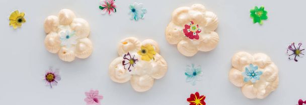 Vista de cima para baixo de um merengues caseiro coberto com flores comestíveis. - Foto, Imagem